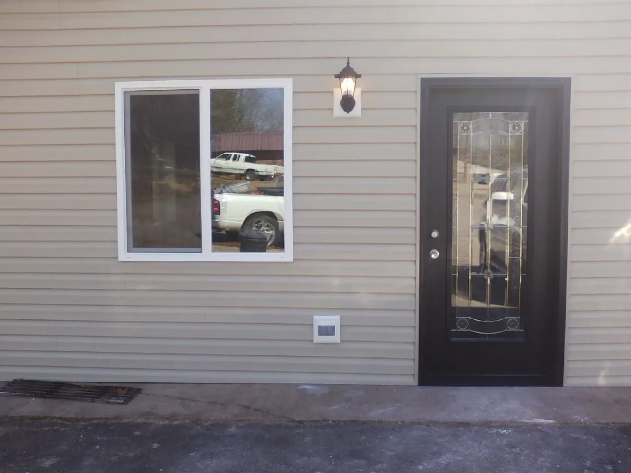 New siding, window and entry door on the side of an addition in Erin