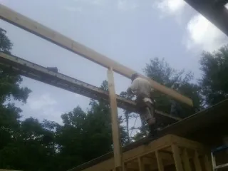 Carpenter setting a ridge beam over a new addition frame — Ice Dam Removal by Roofing Brothers in Erin