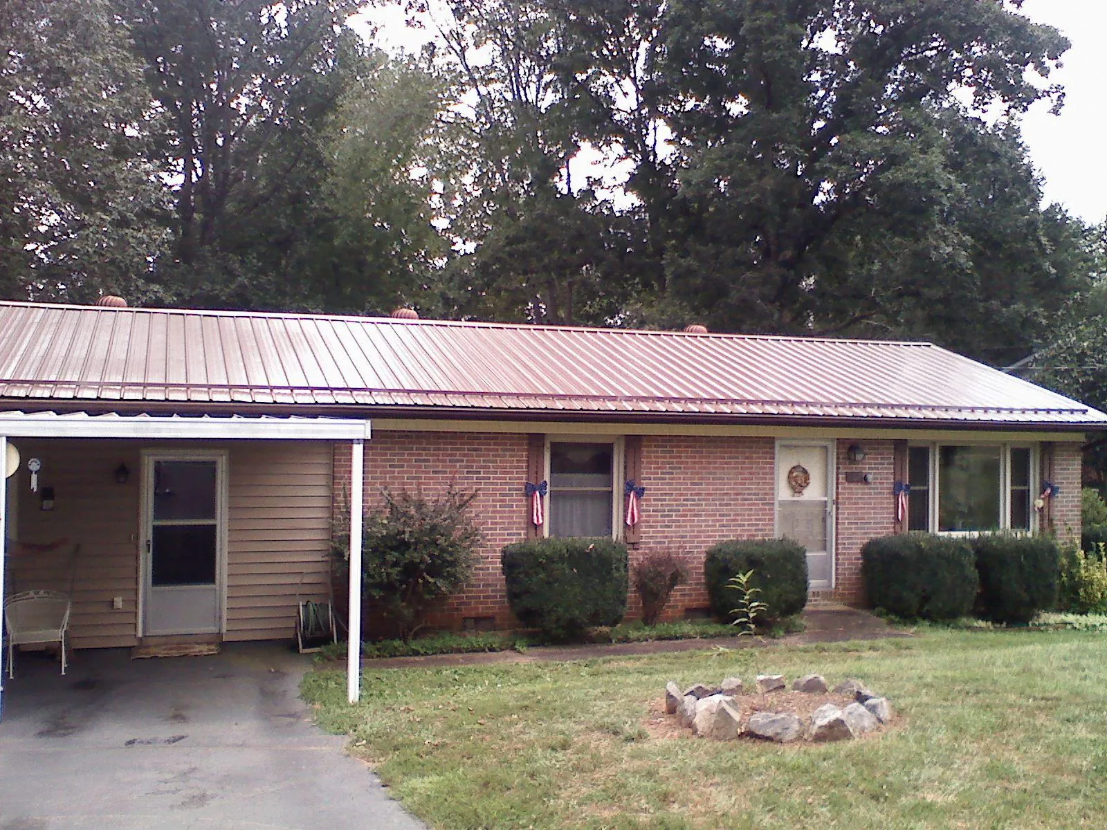 Bronze metal roof and carport on a brick ranch home — Roof Repair work by our crew in Erin