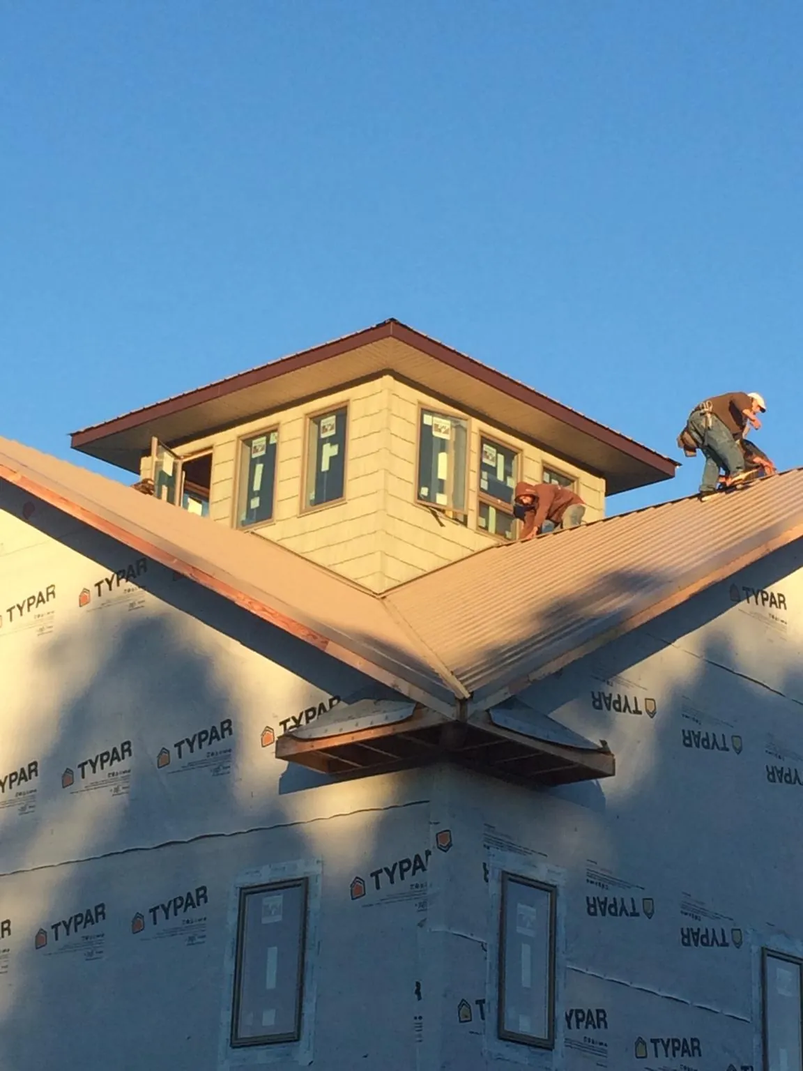 Roofers working around a rooftop cupola on a new metal roof at sunset — Roof Waterproofing in Erin by Roofing Brothers